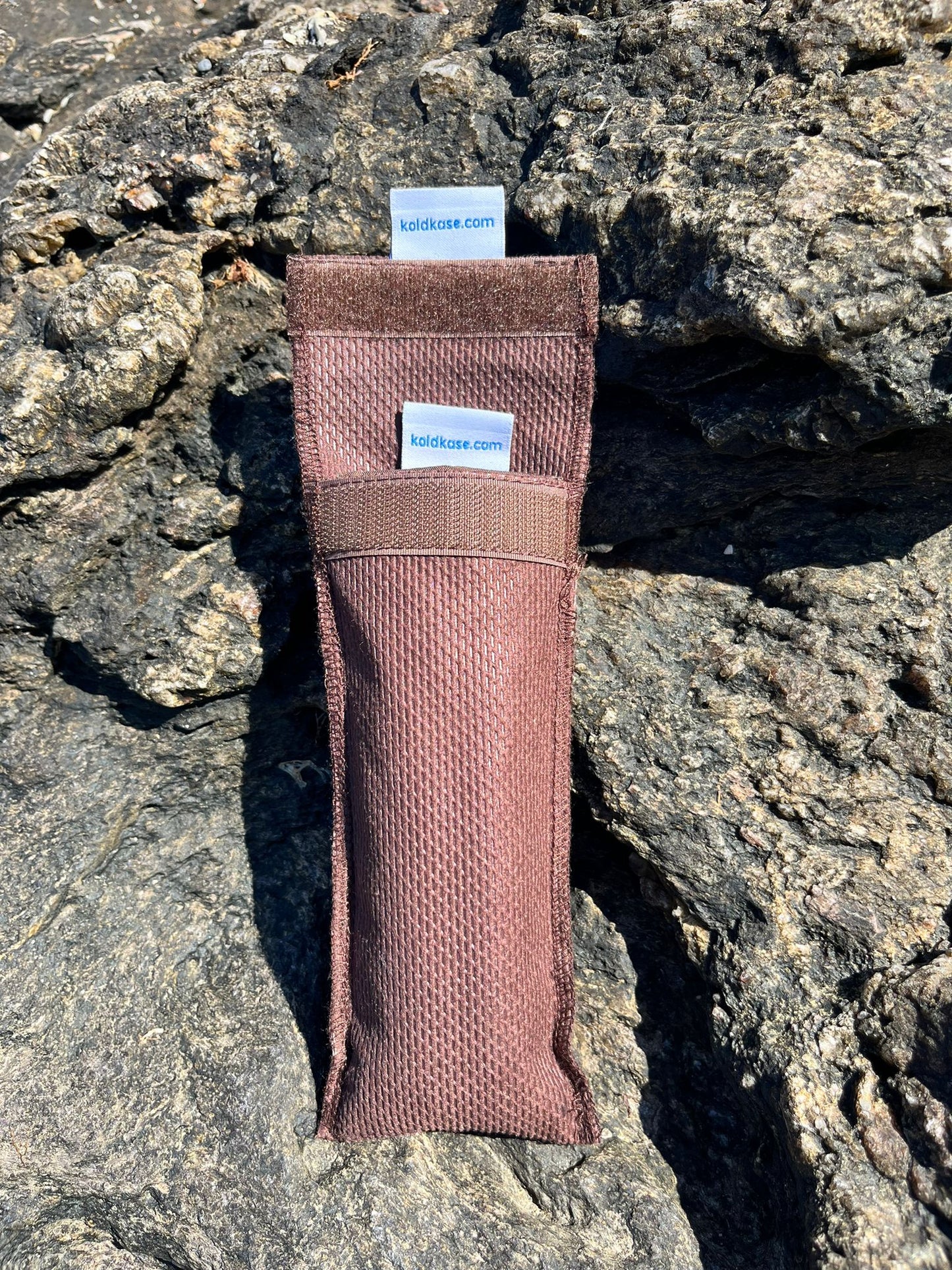 cartera porta insulina para una pluma de color marrón con rocas de fondo