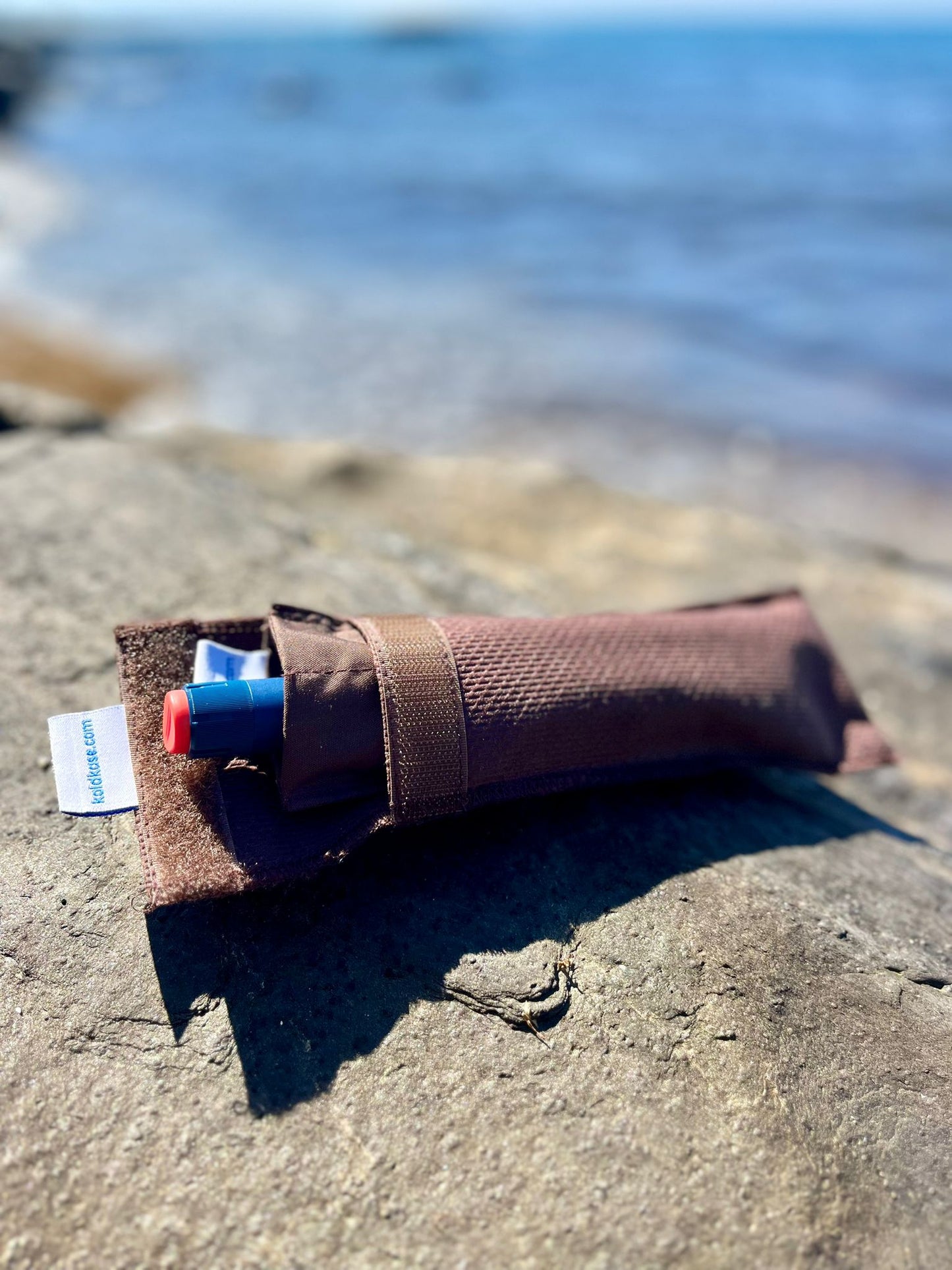 nevera porta insulina para una pluma de color marrón con el mar de fondo difuminado