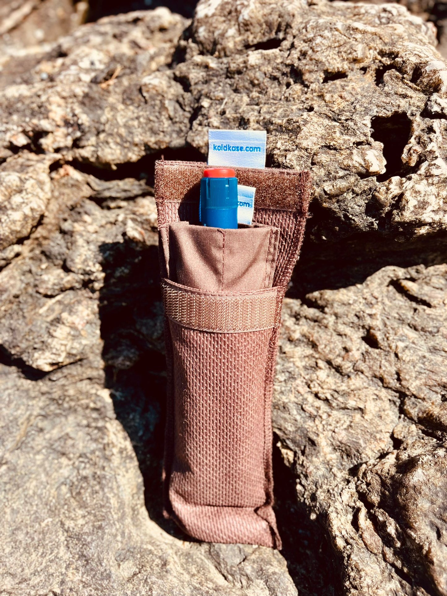 nevera porta insulina para una pluma de color marrón en medio de las rocas